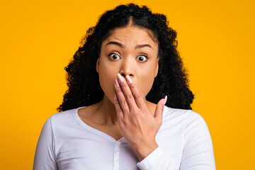 OMG. Portrait Of Shocked Black Woman Covering Mouth With Hand And Looking At Camera, Emotionally...