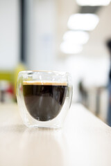 Black coffee in clean transparent glass mug.