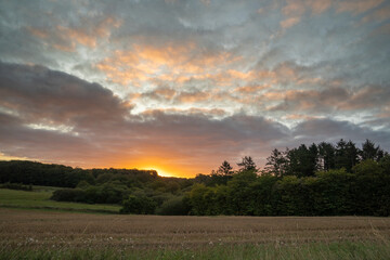 Danish sunrise in beautiful landscape. Dramatic puff clouds and blue hour
