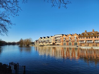 Fototapeta premium A row of buildings with classical architecture on the banks of the River Thames in Windsor, England. It looks bright and clean, calm, peaceful and classy. Beautiful.