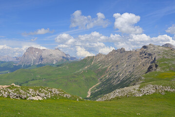 Spectacular panoramic view of the extensive wide plateau of Seiser Alm, Alpe di Siusi, shows the contrast between gentle alpine meadows and the extreme mountain terrain of the Dolomites in Italy.