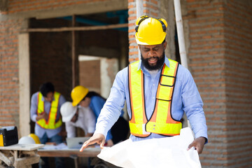 African American male engineer working with blue print : Architect and contractor worker planning...