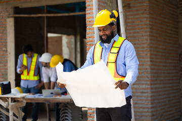 African American male engineer working with blue print : Architect and contractor worker planning...