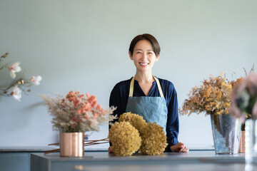  花に囲まれて暮らす女性