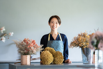  花に囲まれて暮らす女性