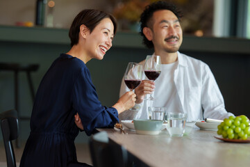 モダンなリビングダイニングで赤ワインを飲む夫婦