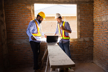 Professional Engineer team Working on Personal Computer at Residential Building Construction site. African American Architect and contractor worker planning and architecture. Professional teamwork