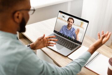 Black Businessman Having Video Call Talking To Laptop With Empty Screen Sitting At Workplace In...