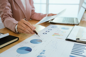 A professional business environment with charts and graphs on a laptop, symbolizing financial analysis, corporate strategy, economic planning, data review, management reporting, growth, consulting, ac