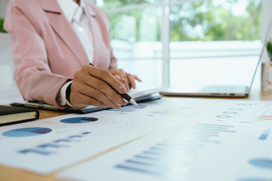 A professional business environment with charts and graphs on a laptop, symbolizing financial analysis, corporate strategy, economic planning, data review, management reporting, growth, consulting, ac - Powered by Adobe