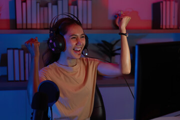 Excited Gamer Celebrating Win. Young woman with headset expressing joy during gaming.