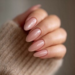 Fototapeta premium Hand with glossy nude manicure in warm sweater