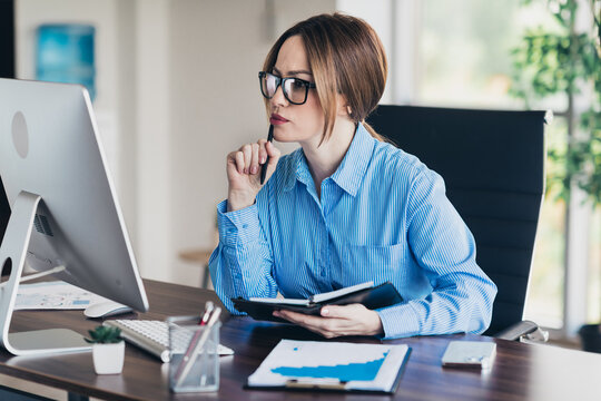 Businesswoman working at desk with focus and determination in modern office environment