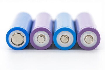 Closeup rechargeable batteries purple blue cylindrical shape metal terminal energy storage isolated...