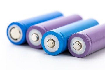 Colorful rechargeable batteries with blue and purple casing arranged in row on white background,...