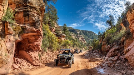Off Road Vehicles Driving Through Rocky Canyon with Bright Blue Sky and Green Mountain Landscape