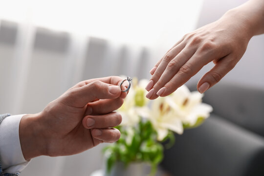 Man with engagement ring making marriage proposal to his girlfriend indoors, closeup - Powered by Adobe