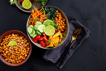 Buddha bowl - vegetarian bowl with chickpeas and fresh vegetables on the black table top view copy space for text