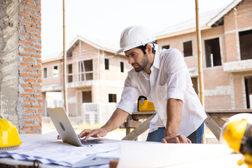 Hispanic male engineer working : Architect and contractor worker planning and architecture working in house building under construction site. Engineering in safety harthat helmet