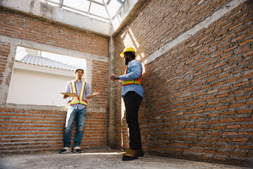 interior design : Architects and contractor working together inside building under construction site. home renovation process. Engineering in safety harthat helmet. Engineering team