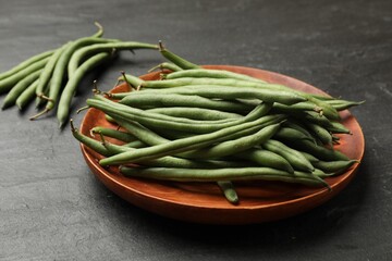 Many raw green beans on black table, closeup