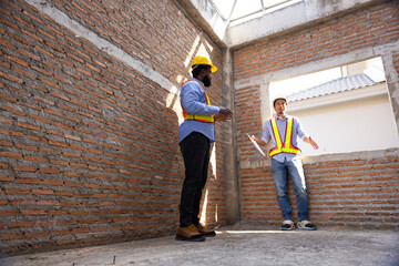 interior design : Architects and contractor working together inside building under construction site. home renovation process. Engineering in safety harthat helmet. Engineering team