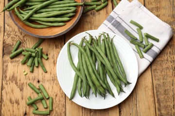 Many raw green beans on wooden table, flat lay