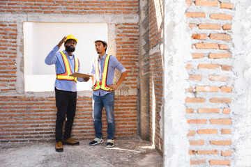 interior design : Architects and contractor working together inside building under construction site. home renovation process. Engineering in safety harthat helmet. Engineering team