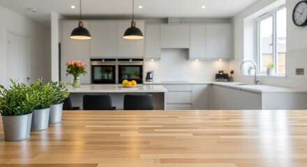Maple butcher block countertop in sharp focus with blurred open-plan kitchen background, light grey cabinetry and greenery accents, natural daylight interior photography for modern stock imagery