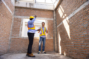interior design : Architects and contractor working together inside building under construction site. home renovation process. Engineering in safety harthat helmet. Engineering team
