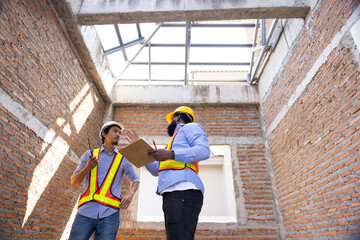 interior design : Architects and contractor working together inside building under construction site. home renovation process. Engineering in safety harthat helmet. Engineering team