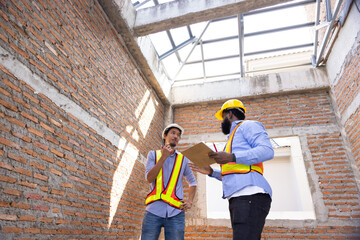 interior design : Architects and contractor working together inside building under construction site. home renovation process. Engineering in safety harthat helmet. Engineering team