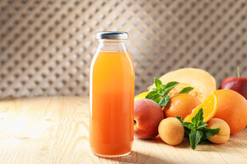 Tasty juice in glass bottle, fresh fruits and mint on wooden table indoors, closeup