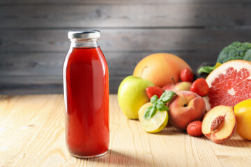 Tasty juice in glass bottle, fresh ingredients and basil on wooden table against brown background, closeup