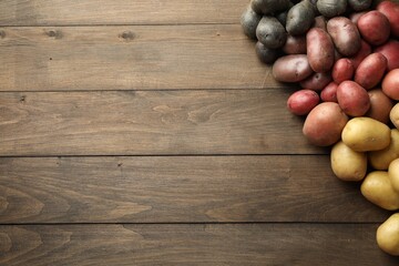 Different types of potatoes on wooden table, flat lay. Space for text