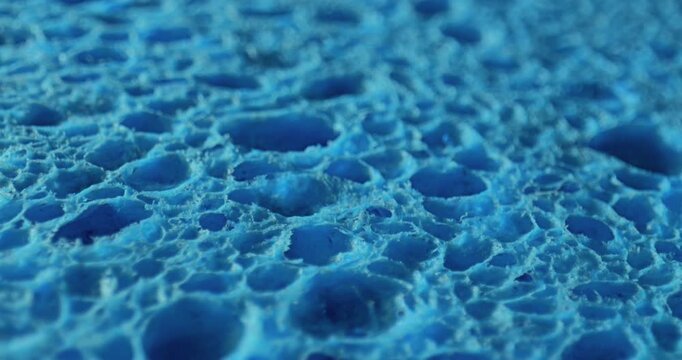 Smooth Linear Drift Over Porous Texture. Video displaying a gentle linear movement across a rugged, porous blue surface.