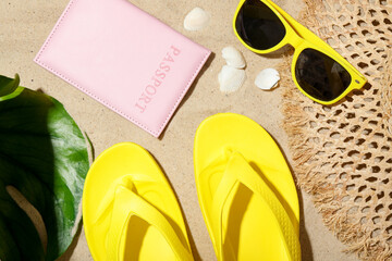 Time for summer vacation. Passport, green leaf and beach accessories on sand, flat lay