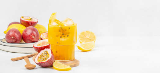 Refreshing passion fruit and lemon juice with ice in a glass on white background. Long banner format. top view. copy space