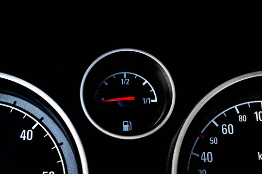 Empty fuel indicator on german car's dashoard, focus on the red needle.