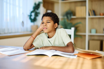 Portrait of a teenage boy having fun writing and doing homework at home