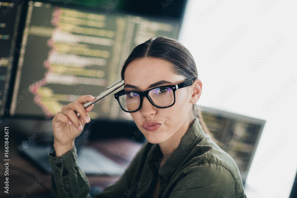 Poster young female programmer analyzing code at her workspace with monitors in a modern and professional s