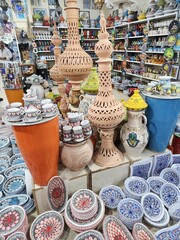 Display of handcrafted pottery and ceramics in a shop with various designs and colors on shelves