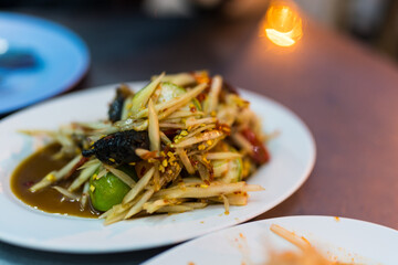 A plate of papaya salad with crab and fermented fish