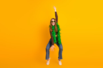 Cheerful Young Woman in Stylish Outfit Striking a Fun Pose with a Yellow Background Highlighting...