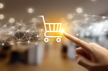 Close-up of hand pointing at shopping cart icon on tablet with digital network overlay