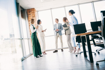 Professional team collaborating in modern office environment with city view promoting business cooperation and teamwork