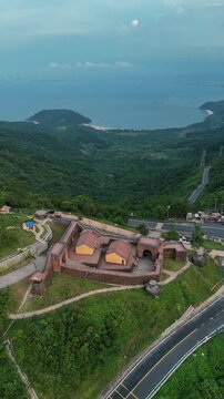 ancient fort on HaiVan Auan gate pass in Vietnam, historic resilience and mountain heritage, old stone Hai Van structure at rugged peak, 4k vertical video