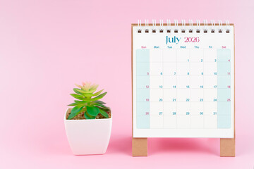 Desk calendar for July 2026 with plant pot on a pink color background.