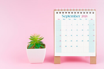 Desk calendar for September 2026 with plant pot on a pink color background.