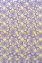 Fototapeta premium die-cut paper overlay featuring a repeating butterfly motif in purple on a faint yellow sheet